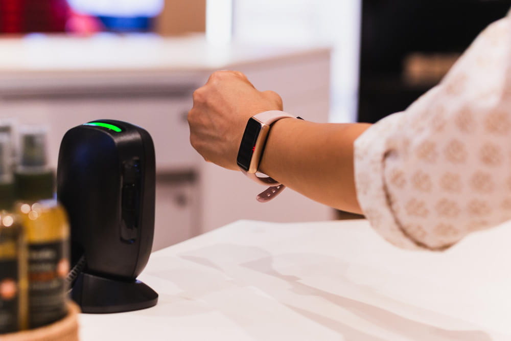 Personne utilisant un bracelet intelligent pour un paiement sans contact, une technologie aussi fluide que celle des bagues connectées